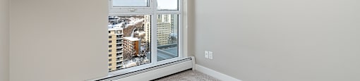 A room with a window overlooking a snowy cityscape.