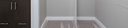 A white closet with a shelf above it.