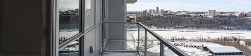 A balcony with a view of a snowy landscape and buildings in the distance.