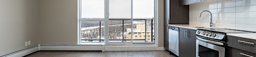 A kitchen with a stove top oven and a window overlooking the city.