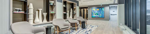 A modern living room with a striped carpet and a long wooden table.