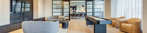 A spacious living room with a grey sofa and a black coffee table.