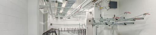 A long hallway with a row of black handles on the left and a row of white machines on the right.