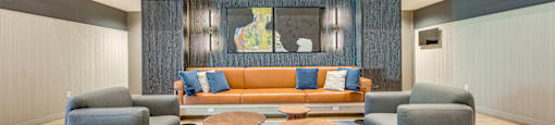 A living room with a couch, two chairs and a coffee table.