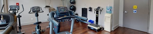 a gym with treadmills and other exercise equipment in a room with a tv at 50 Prince Arthur