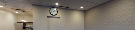 a dining room with a table and chairs and a clock on the wall