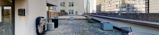 a patio with a table and chairs on the side of a building