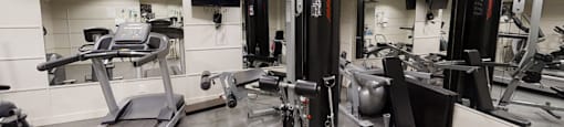 A gym with treadmills, weights, and exercise equipment.