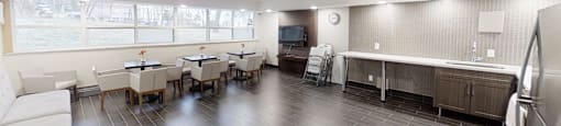 A spacious kitchen and dining area with a white sofa and wooden chairs.