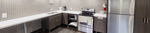 A modern kitchen with stainless steel appliances and a refrigerator.