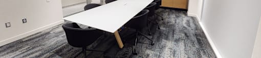 A conference room with a long table and chairs.