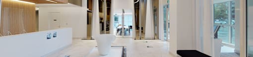 A white reception area with a large white vase in the middle of the room.