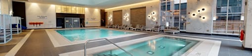 A large indoor swimming pool with a skylight above it.
