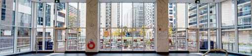 A large indoor swimming pool with a view of the city outside the windows.