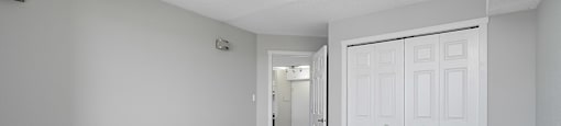 A room with a carpeted floor and a white door.