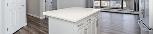A kitchen with white cabinets and a large island.
