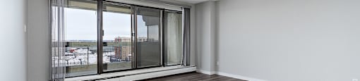 A room with a large window and wooden flooring.
