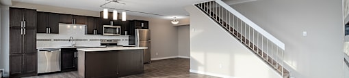 A spacious kitchen with a refrigerator, microwave, and oven.