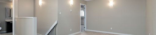 A spacious room with a staircase and two doors.