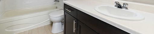 A bathroom with a white sink and a white toilet.