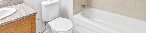A white toilet sits next to a sink in a bathroom.