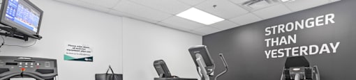 A gym with a sign that says Stronger than Yesterday
