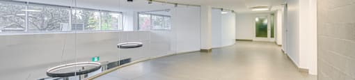 a long hallway with white walls and white tile floors and a table with a window
