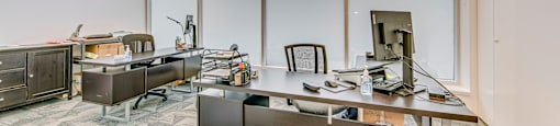 a large office with two desks and a large window