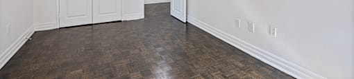 an empty living room with white walls and wood flooring