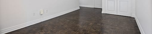 an empty living room with white walls and wood floors