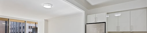 a kitchen with white cabinets and a stainless steel refrigerator at 50 Prince Arthur