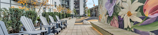 A row of grey chairs are lined up on a patio.