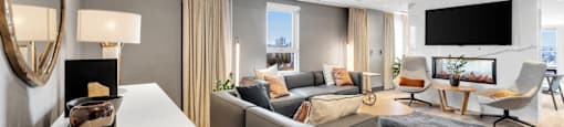 A modern living room with a grey sofa and a white coffee table.