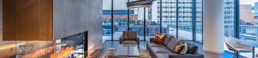 A modern living room with a fireplace and a view of the city.