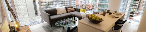 A modern living room with a large window and a kitchen area.