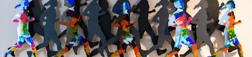 A wall of paper cut outs of people running.
