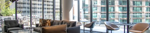 A modern living room with a large window and a variety of chairs and couches.