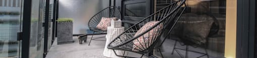 A balcony with two chairs and a table.