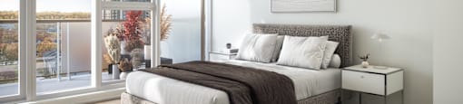 a bedroom with a large window and a bed