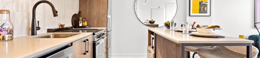 a kitchen with an island with stools and a sink and a mirror