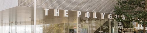 The PolyGym is a modern gym with a glass facade and outdoor seating area.