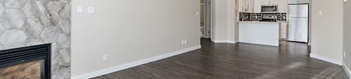 A spacious living room with a fireplace and hardwood floors.