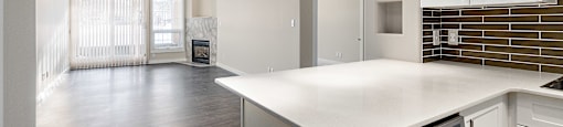 A kitchen with a white counter top and a dishwasher.
