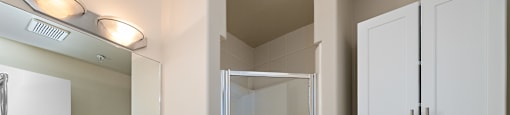 A white bathroom with a toilet, sink, and shower.