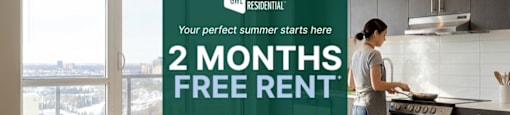 A woman is cooking in a modern kitchen with a sign offering 2 months free rent.