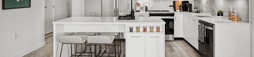 A modern kitchen with white cabinets and a large island.