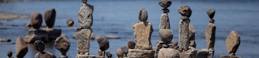 stone sculptures on a dock near a body of water