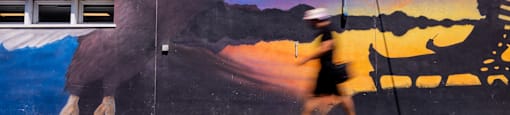 a person walking by a wall with a large eagle on it