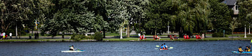 people on boats on a lake in a park