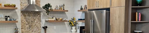 A modern kitchen with wooden cabinets and a stainless steel refrigerator.
